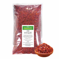 Chili geschrotet mild 2-4 mm, Chiliflocken, im Siegelrandbeutel mit Chiliflocken in einer Tonschale davor.