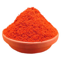 Paprika Edelsüß gemahlen in einer Tonschale auf weißem Grund.
